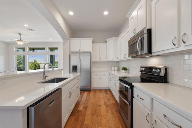 20213 Hidden Gully Ln, Pflugerville, TX 78660 - kitchen featuring stainless steel appliances, a sink, tasteful backsplash, recessed lighting, and white cabinetry
