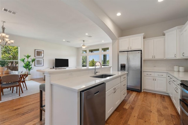 20213 Hidden Gully Ln, Pflugerville, TX 78660 - kitchen featuring appliances with stainless steel finishes, a sink, a kitchen island with sink, light countertops, and recessed lighting