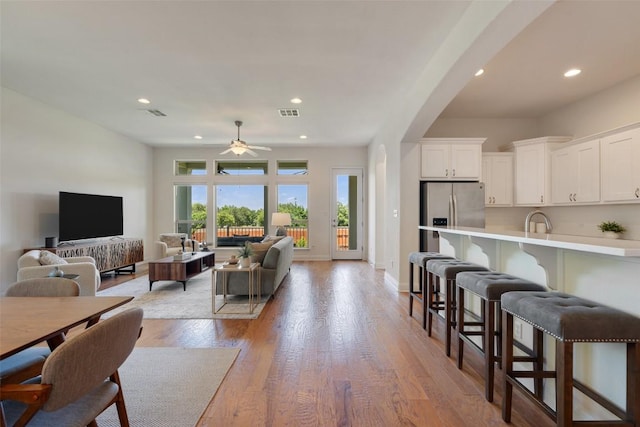 20213 Hidden Gully Ln, Pflugerville, TX 78660 - living room featuring ceiling fan, light wood-style flooring, arched walkways, recessed lighting, and baseboards