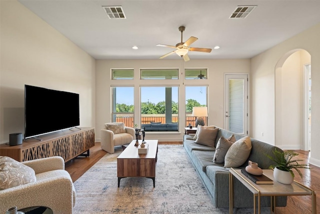 20213 Hidden Gully Ln, Pflugerville, TX 78660 - living room with arched walkways, a ceiling fan, wood finished floors, baseboards, and recessed lighting