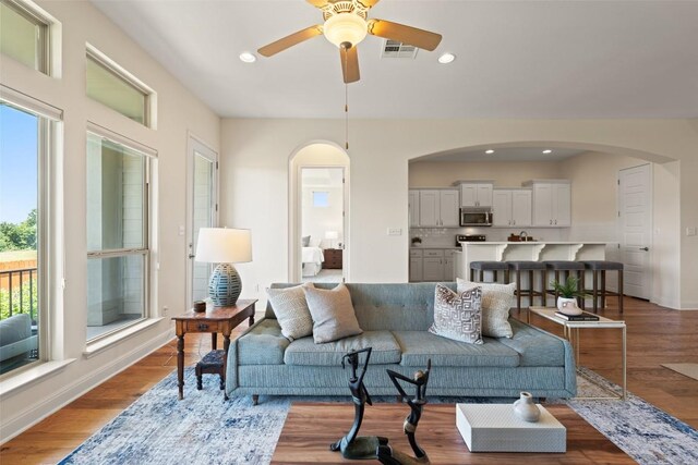 20213 Hidden Gully Ln, Pflugerville, TX 78660 - living room featuring arched walkways, ceiling fan, recessed lighting, wood finished floors, and baseboards