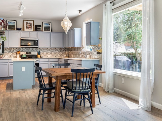 12705 Bransford Cv, Austin, TX 78753 - kitchen with appliances with stainless steel finishes, gray cabinets, backsplash, and light countertops