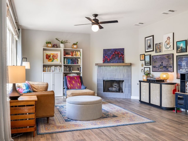 12705 Bransford Cv, Austin, TX 78753 - living room with a ceiling fan, wood finished floors, and a tiled fireplace