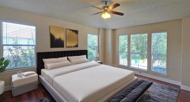 bedroom featuring a textured ceiling, baseboards, wood finished floors, and a ceiling fan
