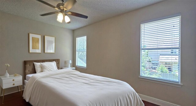 bedroom featuring a textured ceiling, baseboards, and ceiling fan