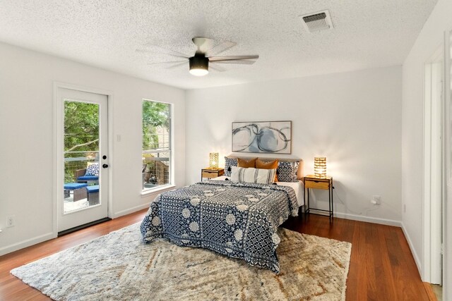 12707 Palfrey Dr, Austin, TX 78727 - bedroom with access to exterior, wood finished floors, baseboards, ceiling fan, and a textured ceiling
