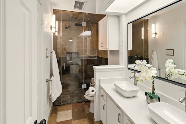 12707 Palfrey Dr, Austin, TX 78727 - bathroom featuring double vanity, a stall shower, and stone finish floors