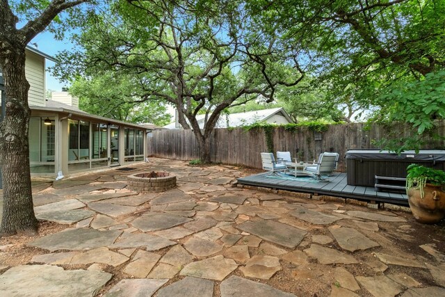 12707 Palfrey Dr, Austin, TX 78727 - fenced backyard with a hot tub, a fire pit, a patio, and a sunroom