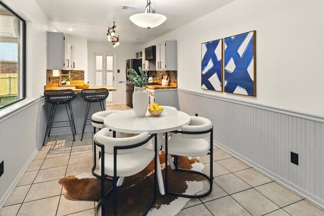 12707 Palfrey Dr, Austin, TX 78727 - dining room featuring light tile patterned floors and a wainscoted wall