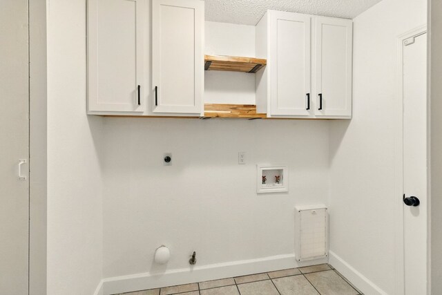 12707 Palfrey Dr, Austin, TX 78727 - laundry area with electric dryer hookup, hookup for a washing machine, baseboards, light tile patterned floors, and cabinet space
