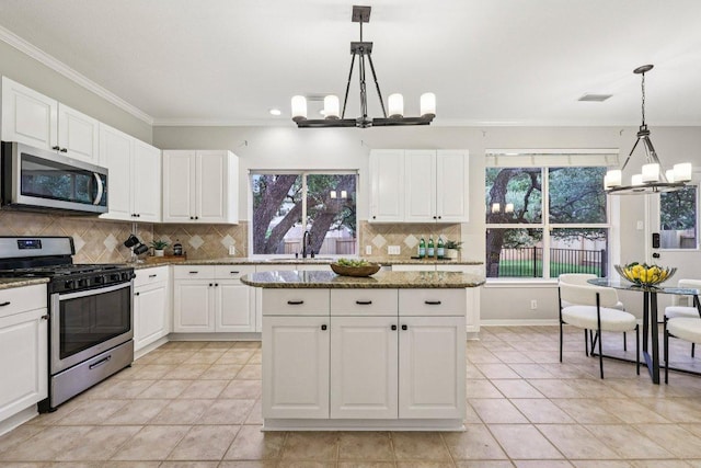 10113 Cassandra Dr, Austin, TX 78717 - kitchen with appliances with stainless steel finishes, a chandelier, light tile patterned floors, ornamental molding, and white cabinets