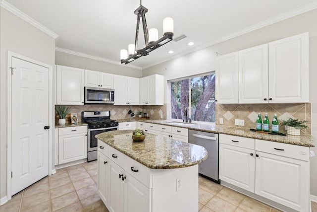 10113 Cassandra Dr, Austin, TX 78717 - kitchen featuring appliances with stainless steel finishes, a sink, white cabinets, crown molding, and a kitchen island