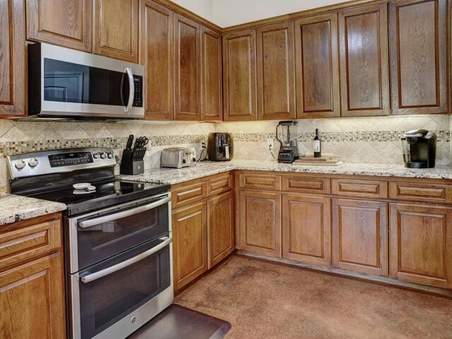 247 Campfire Way, Smithville, TX 78957 - kitchen with stainless steel appliances, backsplash, and light stone counters