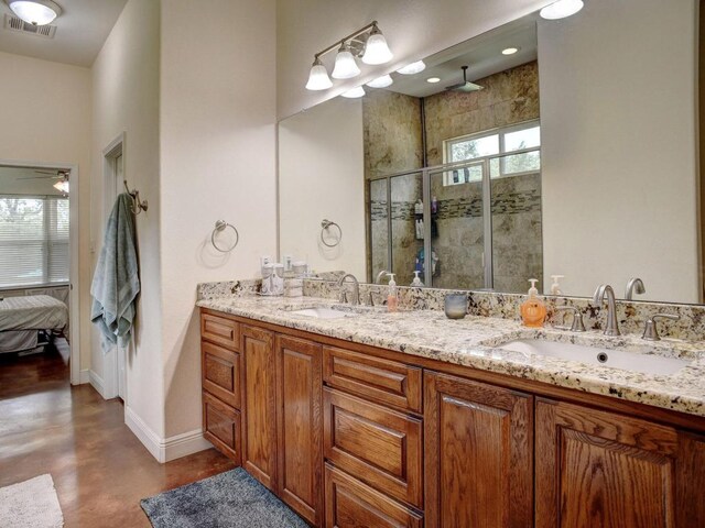 247 Campfire Way, Smithville, TX 78957 - full bath with concrete flooring, a shower stall, double vanity, baseboards, and ensuite bath