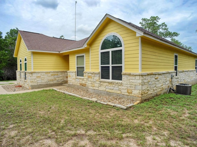 247 Campfire Way, Smithville, TX 78957 - view of side of property with stone siding, central AC unit, a lawn, and roof with shingles