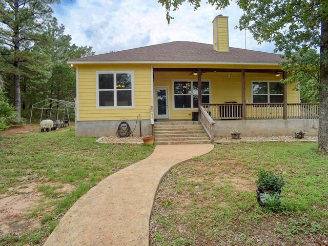 247 Campfire Way, Smithville, TX 78957 - view of front facade with a chimney, a porch, a front lawn, and a ceiling fan