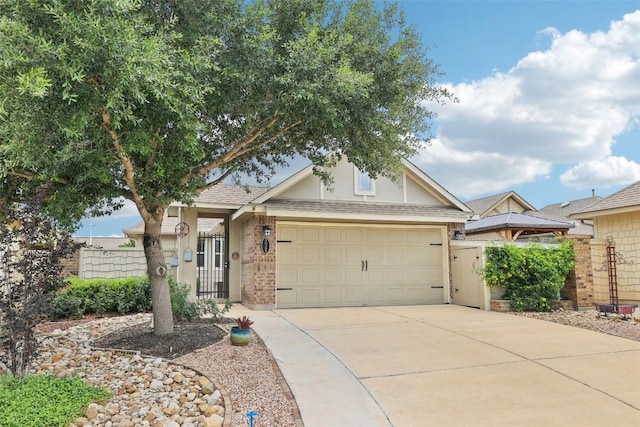 238 Rock Bluff Ln, San Marcos, TX 78666 - view of front of home featuring driveway, brick siding, a gate, an attached garage, and a shingled roof