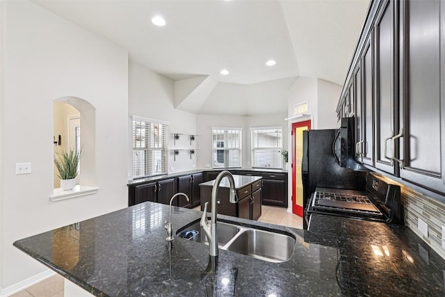 238 Rock Bluff Ln, San Marcos, TX 78666 - kitchen featuring black appliances, lofted ceiling, a center island, a peninsula, and dark stone counters