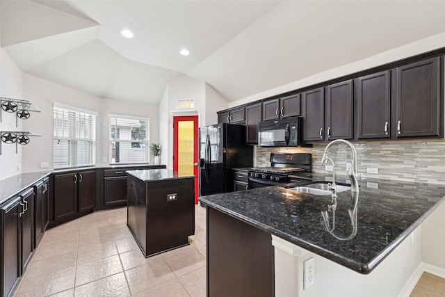 238 Rock Bluff Ln, San Marcos, TX 78666 - kitchen with black appliances, a peninsula, dark stone counters, vaulted ceiling, and backsplash