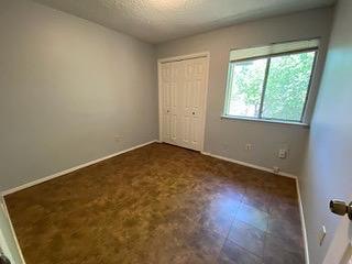 1402 Waterloo Trl, Austin, TX 78704 - unfurnished bedroom featuring baseboards, a closet, and a textured ceiling