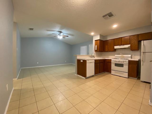 1402 Waterloo Trl, Austin, TX 78704 - kitchen featuring white appliances, under cabinet range hood, open floor plan, light countertops, and a peninsula