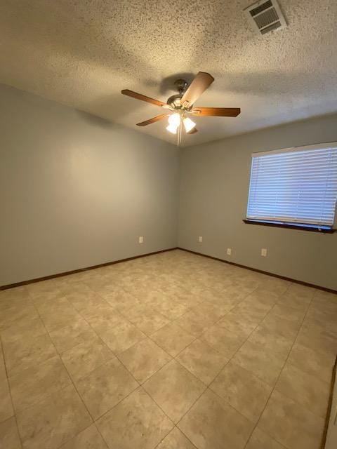 1402 Waterloo Trl, Austin, TX 78704 - empty room featuring ceiling fan, a textured ceiling, baseboards, and light tile patterned floors
