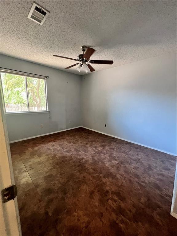 1402 Waterloo Trl, Austin, TX 78704 - spare room with a ceiling fan, a textured ceiling, and baseboards