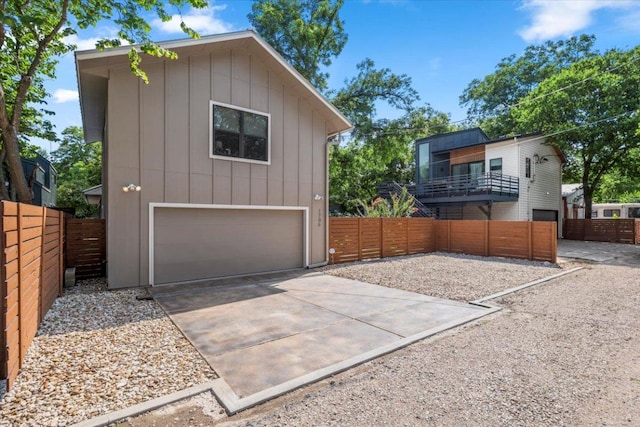 1706 Canterbury St, Austin, TX 78702 - view of property exterior with an attached garage, driveway, and board and batten siding
