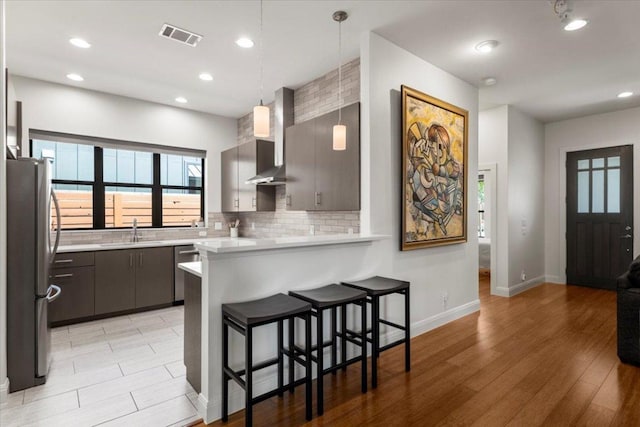 1706 Canterbury St, Austin, TX 78702 - kitchen featuring a sink, appliances with stainless steel finishes, a peninsula, decorative backsplash, and a kitchen bar
