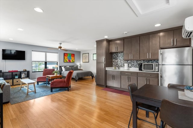 1706 Canterbury St, Austin, TX 78702 - kitchen featuring stainless steel appliances, open floor plan, dark brown cabinets, light countertops, and light wood-style floors