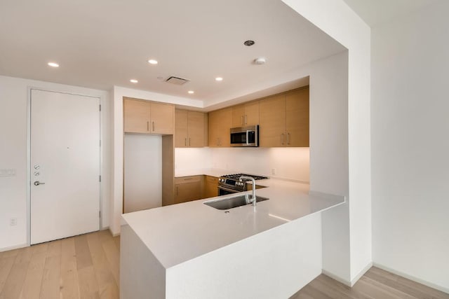 301 W Ave Unit 2003, Austin, TX 78701 - kitchen featuring stainless steel appliances, light countertops, light wood finished floors, a peninsula, and recessed lighting