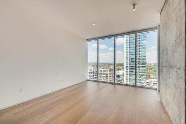 301 W Ave Unit 2003, Austin, TX 78701 - spare room featuring a wall of windows, wood finished floors, and a city view