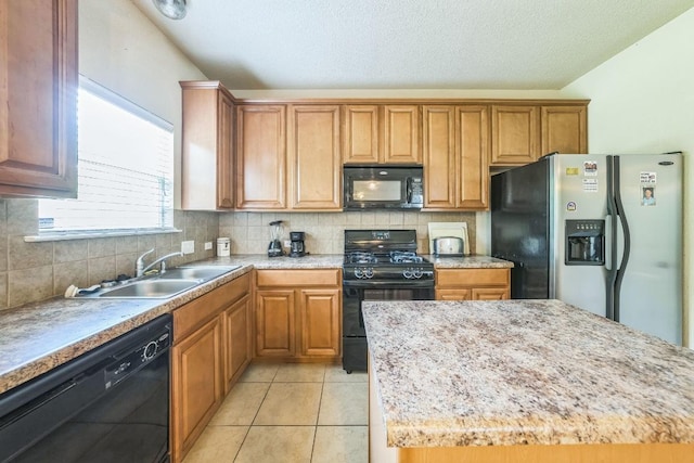 633 Sweet Leaf Ln, Pflugerville, TX 78660 - kitchen featuring black appliances, a sink, tasteful backsplash, brown cabinets, and a textured ceiling