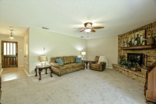 304 White Wing Way, Round Rock, TX 78664 - carpeted living area featuring a ceiling fan, a brick fireplace, baseboards, a textured ceiling, and tile patterned flooring