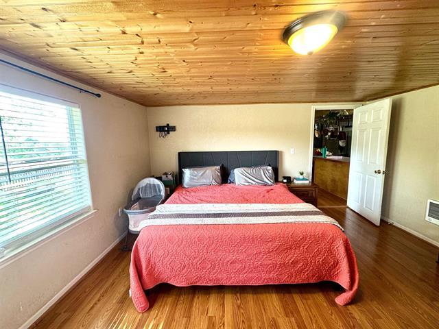 1415 Bee Ln, Tow, TX 78672 - bedroom with wooden ceiling, wood finished floors, and baseboards
