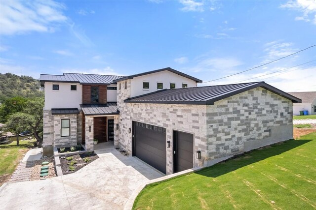 335 Sandy Mountain Dr, Sunrise Beach, TX 78643 - contemporary house with a standing seam roof, stone siding, metal roof, and driveway
