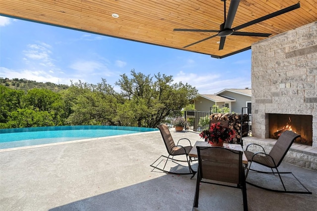 335 Sandy Mountain Dr, Sunrise Beach, TX 78643 - view of patio featuring an outdoor stone fireplace, a ceiling fan, and outdoor dining area