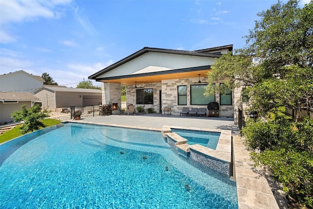 335 Sandy Mountain Dr, Sunrise Beach, TX 78643 - rear view of property with a patio area, a pool with connected hot tub, and stone siding