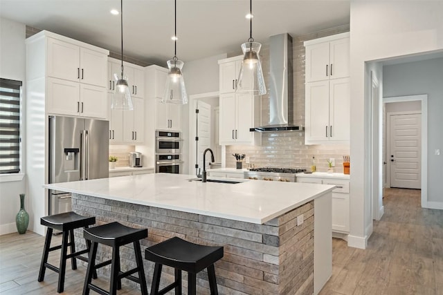 335 Sandy Mountain Dr, Sunrise Beach, TX 78643 - kitchen with wall chimney exhaust hood, a sink, stainless steel appliances, decorative backsplash, and baseboards