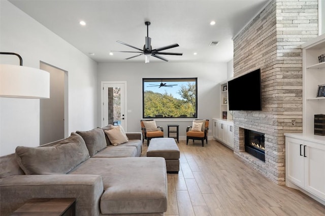 335 Sandy Mountain Dr, Sunrise Beach, TX 78643 - living room featuring a ceiling fan, light wood-type flooring, recessed lighting, and a large fireplace