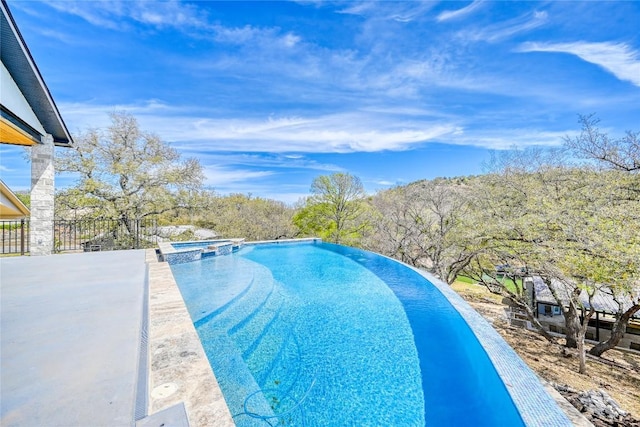 335 Sandy Mountain Dr, Sunrise Beach, TX 78643 - view of swimming pool featuring a pool with connected hot tub and a patio area
