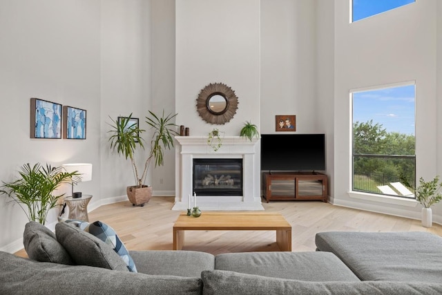 1501 University Club Dr, Austin, TX 78732 - living room with a towering ceiling, wood finished floors, a glass covered fireplace, and baseboards