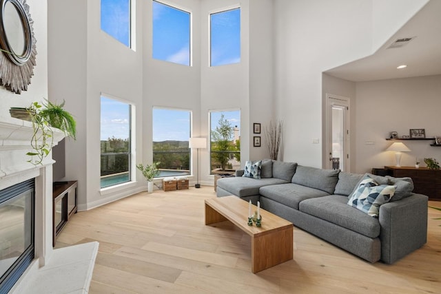 1501 University Club Dr, Austin, TX 78732 - living area with light wood-type flooring, a high ceiling, a premium fireplace, and baseboards