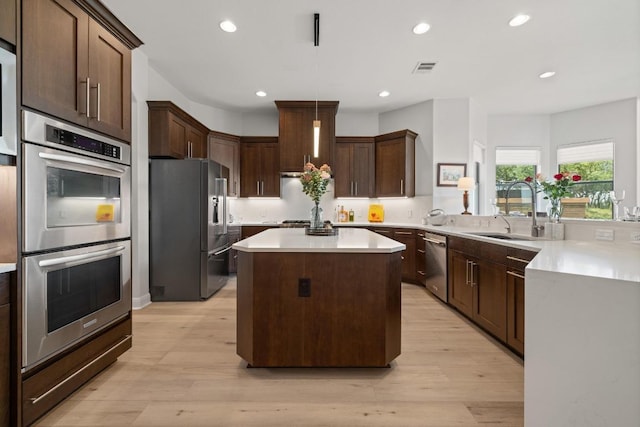 1501 University Club Dr, Austin, TX 78732 - kitchen featuring stainless steel appliances, light countertops, light wood-type flooring, a kitchen island, and recessed lighting