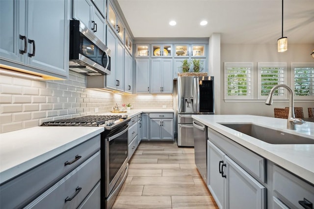 5820 Harper Park Dr Unit 66, Austin, TX 78735 - kitchen featuring appliances with stainless steel finishes, a sink, light wood-style floors, light countertops, and recessed lighting