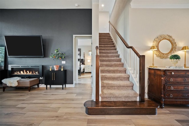 5820 Harper Park Dr Unit 66, Austin, TX 78735 - stairs with wood finished floors, ornamental molding, and a lit fireplace