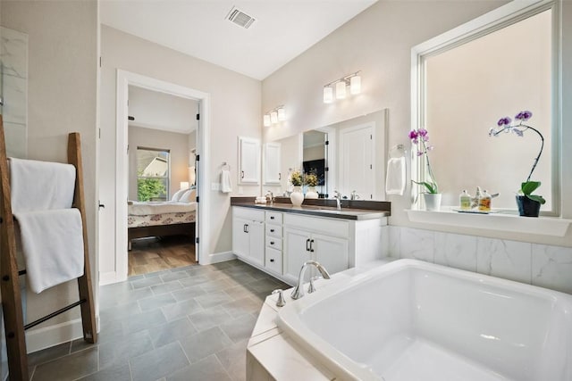 5820 Harper Park Dr Unit 66, Austin, TX 78735 - bathroom featuring a bath, double vanity, connected bathroom, and baseboards