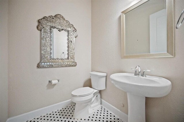 5820 Harper Park Dr Unit 66, Austin, TX 78735 - half bath featuring toilet, baseboards, a sink, and tile patterned floors