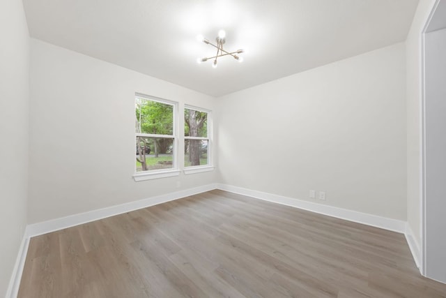 13322 Villa Park Dr, Austin, TX 78729 - unfurnished room featuring a chandelier, wood finished floors, and baseboards