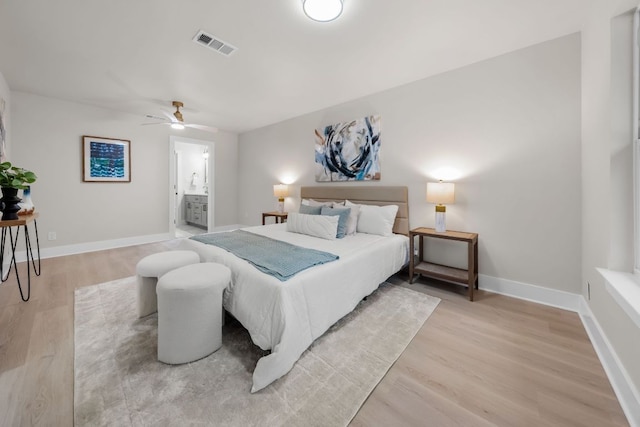 13322 Villa Park Dr, Austin, TX 78729 - bedroom with light wood-style floors, baseboards, and connected bathroom